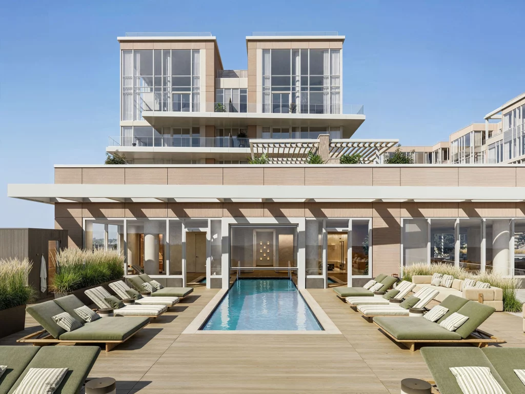 LIDO Asbury Park South Pool with chaise lounge chairs and a modern, rectangular swimming pool, and upscale condominium residences visible in the background.