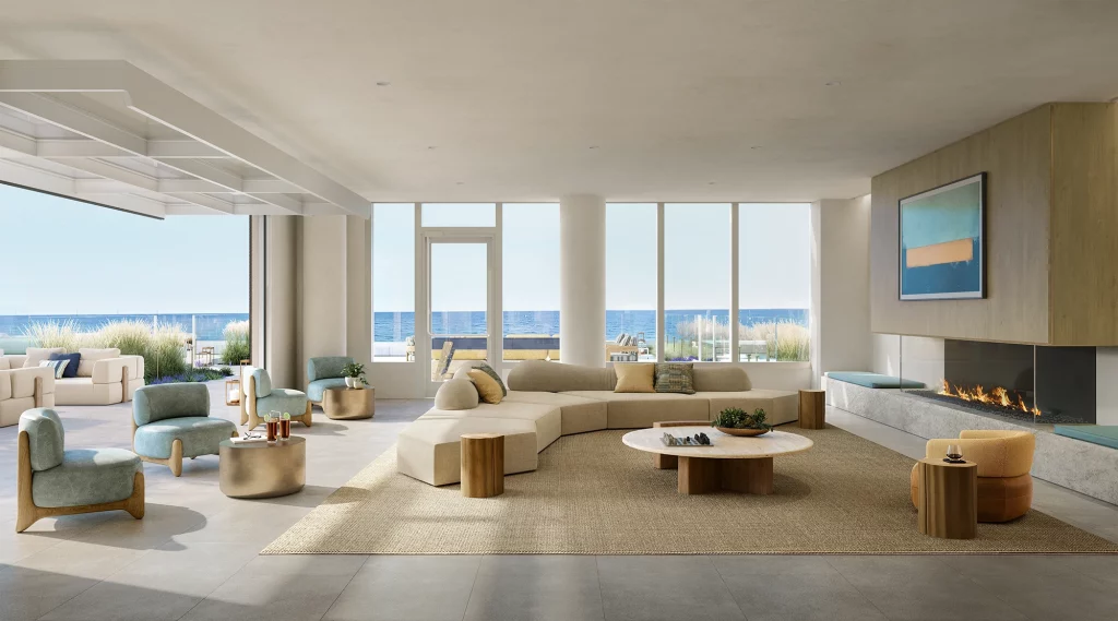 Activity Lounge at LIDO Asbury Park with large sofa and plush seating, a modern fireplace, and floor-to-ceiling windows with panoramic ocean views.